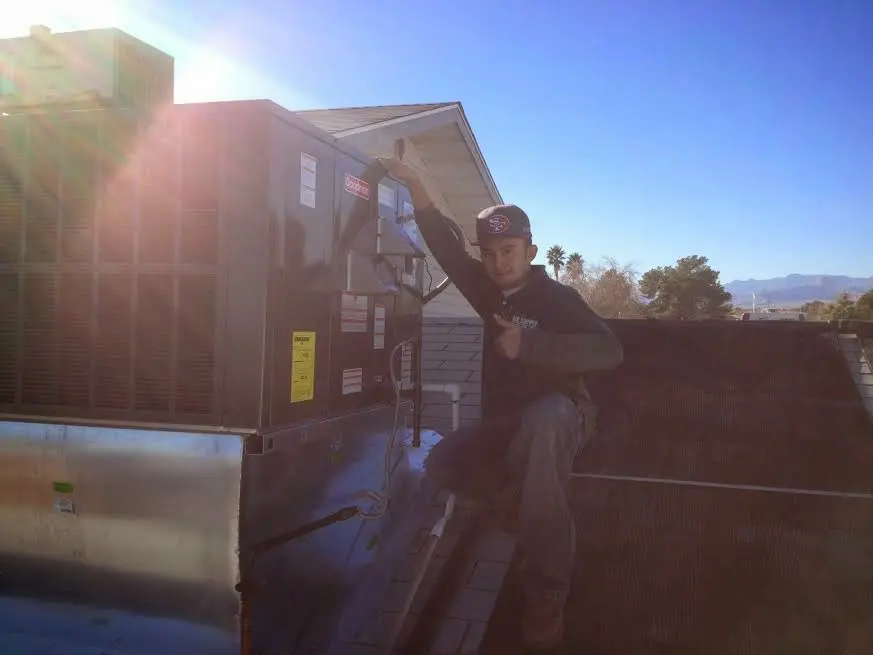 HVAC technician performing HVAC Inspection on a rooftop unit in Brentwood